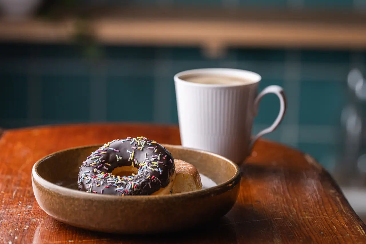 Madfotografi af donut med chokolade og kop kaffe for AAK, taget af Skovgaard & Damgaard – specialister i branding, fotografering og visuel kommunikation.