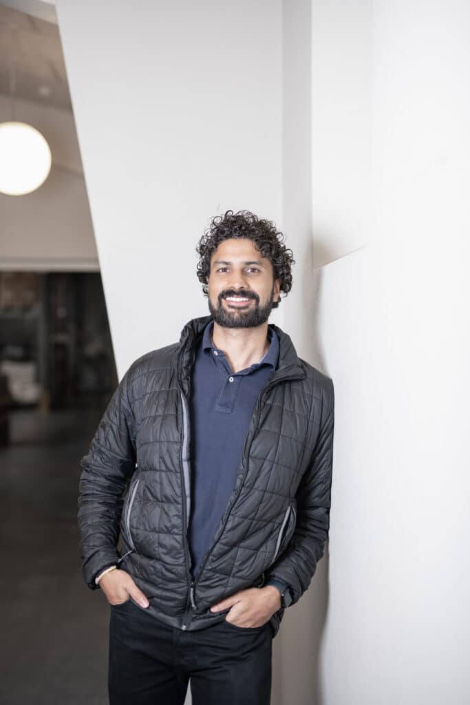 Portrætfotografi af Pranay Krishen fra Linc smiler og står foran et hvidt baggrund