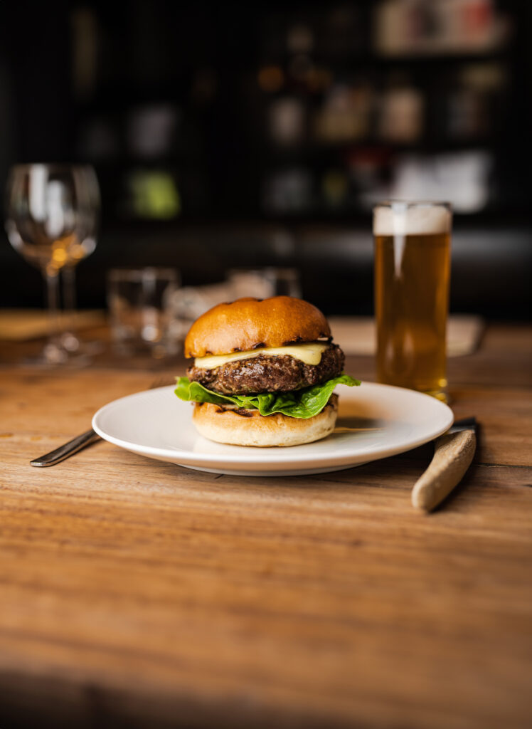 Burger fra A Hereford Beefstouw med øl i baggrunden