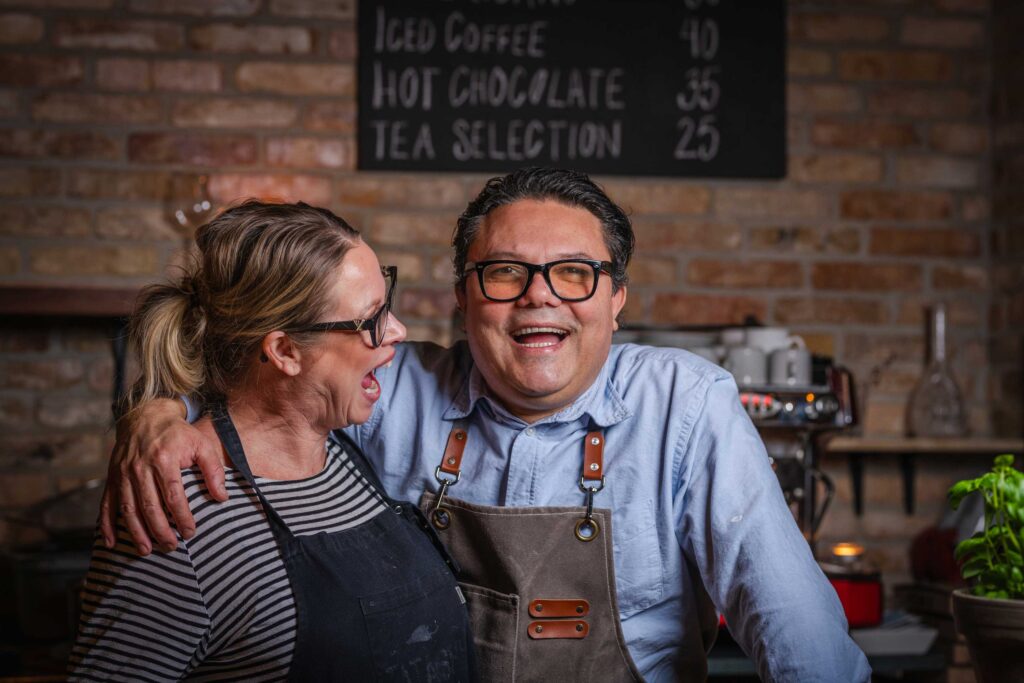 Jenny og Marcelo, ejere af Ceres Trattoria, smilende i restauranten.