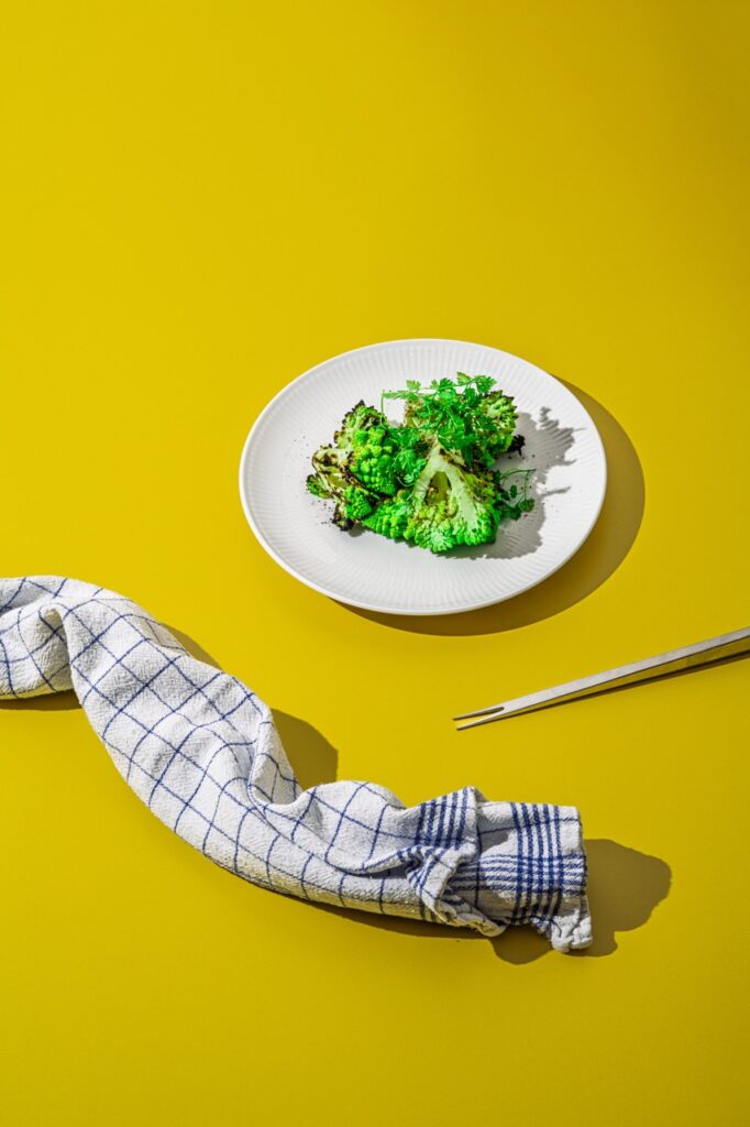 Vegetarisk servering med grillet romanesco og friske krydderurter på hvid tallerken – professionelt madfoto af Skovgaard &amp; Damgaard