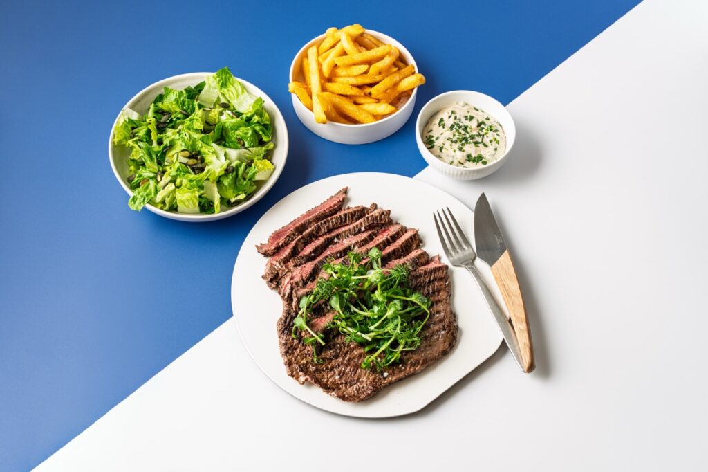Grillet oksekød med pommes frites, grøn salat og sauce – madfotografi af Skovgaard & Damgaard Grillet oksekød med salat, pommes frites og urtesauce – professionelt madfoto af Skovgaard & Damgaard