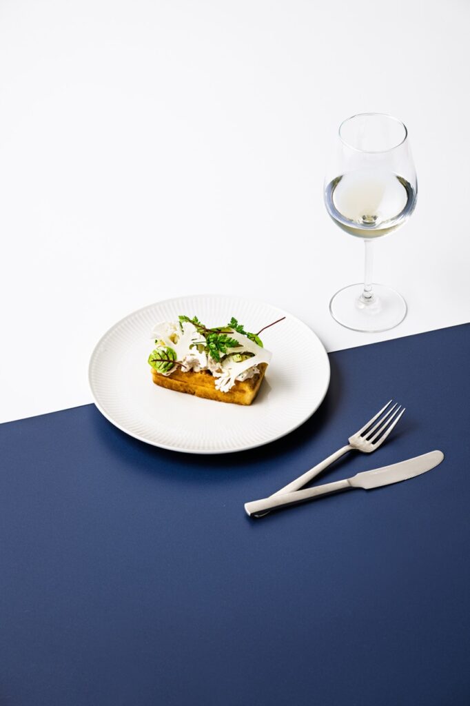 Hønsesalat med blomkål og urter på vaffel – elegant madfoto af Skovgaard & Damgaard Hønsesalat på vaffel med rå blomkål og friske urter – professionelt madfotografi af Skovgaard & Damgaard