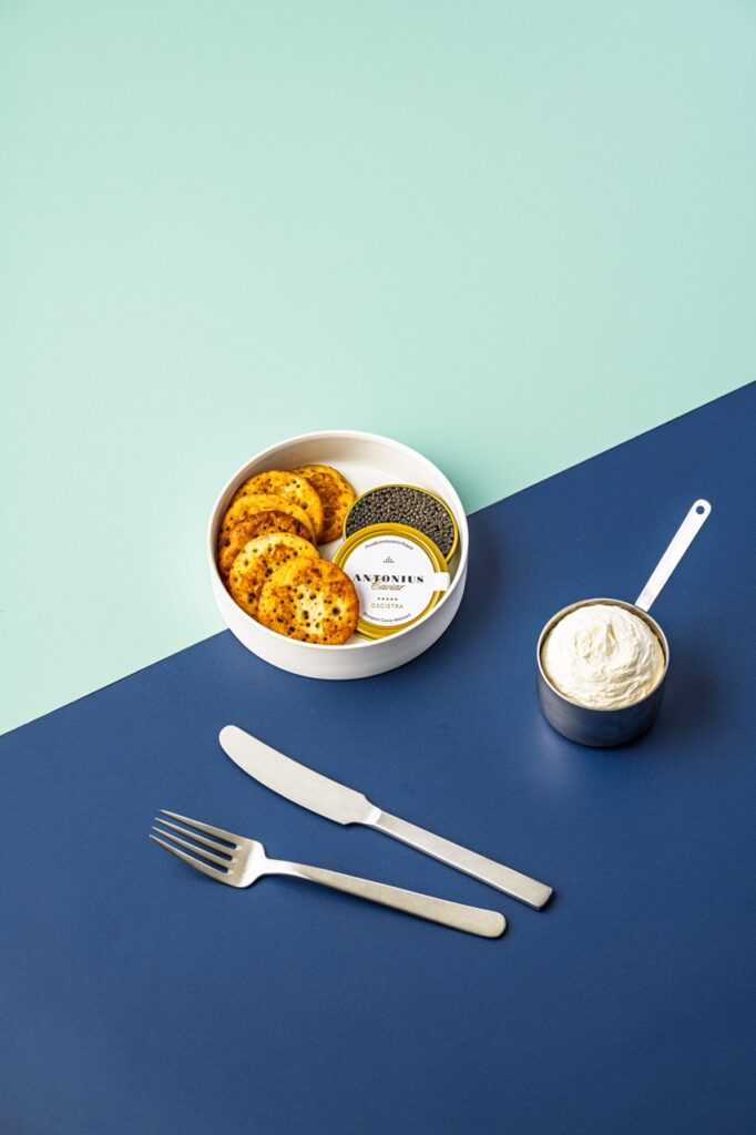 Luksusservering med caviar og creme fraiche – foto af Skovgaard & Damgaard. Skål med kiks og caviar samt målekop med creme fraiche, fotograferet af Skovgaard & Damgaard.