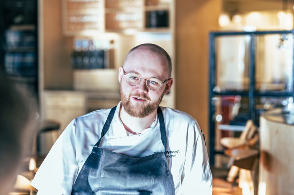 Erhvervsportrætter af Skovgaard & Damgaard – tidligere køkkenchef på Molskroens Strandhotel, Nikolaj Wilhardt, med professionel og autentisk tilstedeværelse Erhvervsportræt af tidligere køkkenchef på Molskroens Strandhotel, Nikolaj Wilhardt, i køkkenuniform, fotograferet af Skovgaard & Damgaard.