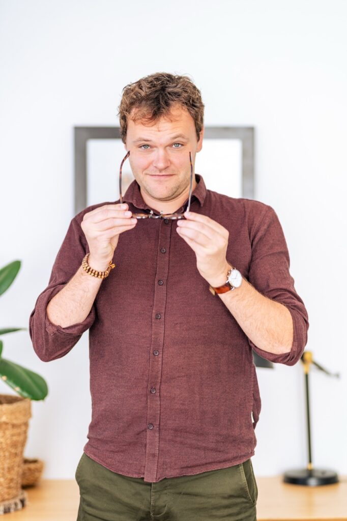 Portrætfotografering af Skovgaard & Damgaard – autentisk portræt af psykoterapeut i praksismiljø Psykoterapeut i afslappet og professionel positur i lyst praksismiljø, fotograferet af Skovgaard & Damgaard.