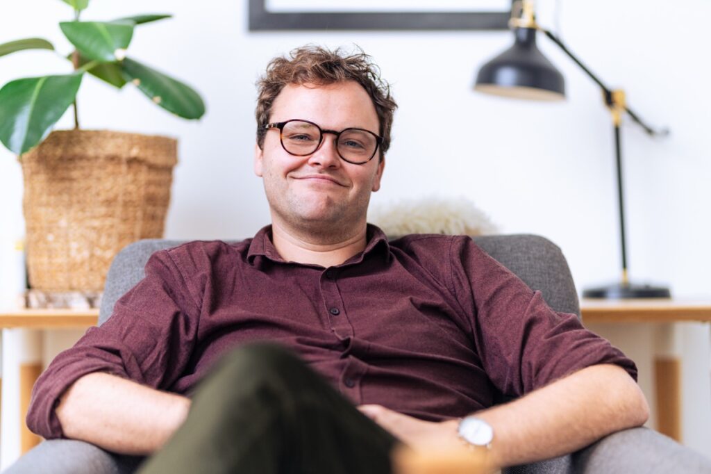 Portrætfotografering af Skovgaard & Damgaard – autentisk erhvervsportræt af psykoterapeut i samtalerum Afslappet portræt af psykoterapeut siddende i praksis, fotograferet af Skovgaard & Damgaard.