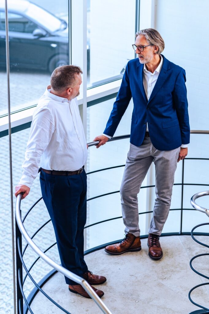 Portrætfotografering af Skovgaard & Damgaard – erhvervsportræt af founders af UNIwise Rasmus Blok og Steffen Skovfoged fra UNIwise i samtale på kontortrappe, professionelt erhvervsportræt fotograferet af Skovgaard & Damgaard.