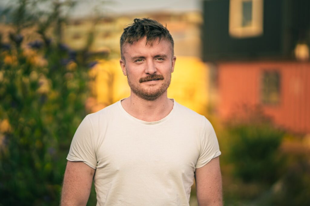 Professionelt erhvervsportræt af ung mand i naturligt lys, fotograferet af Skovgaard &amp; Damgaard.