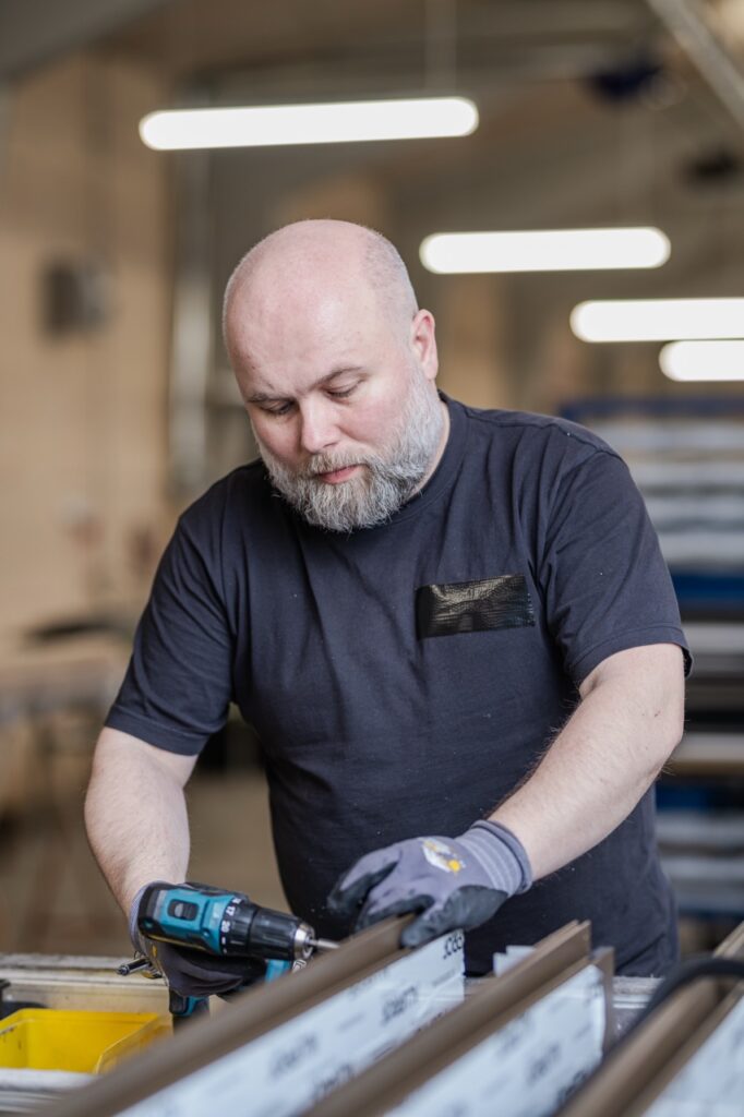 Erhvervsfotografering af Skovgaard & Damgaard – medarbejderportræt og koncentreret håndværk hos AS Facader Erhvervsportræt af en medarbejder hos AS Facader, der udfører præcist håndværk med værktøj, fotograferet af Skovgaard & Damgaard.