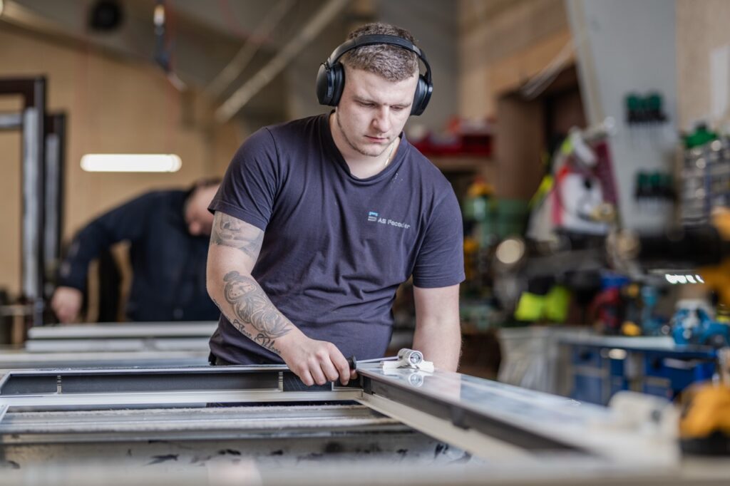 Erhvervsfotografering af Skovgaard & Damgaard – medarbejderportræt og præcisionsarbejde hos AS Facader i Ikast Erhvervsportræt af en medarbejder hos AS Facader i Ikast, der arbejder præcist med en facadekomponent, fotograferet af Skovgaard & Damgaard.