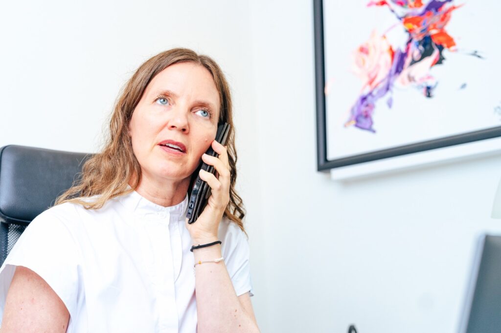 Administrativ koordinator hos Neuropsykologisk Praksis i Aarhus i telefonisk samtale, fotograferet af erhvervsfotograf Skovgaard &amp; Damgaard.