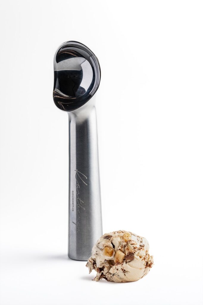 Brandet is-scooper fra Kastbergs Is med en kugle cookie dough-is, fotograferet i professionel produktfotografering af Skovgaard &amp; Damgaard.