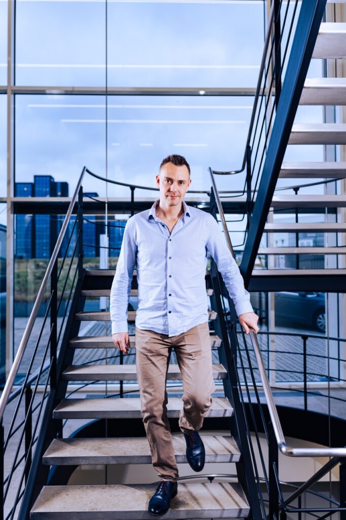 Sune Kj&aelig;rg&aring;rd, CPTO hos UNIwise, portr&aelig;tteret p&aring; trappe i moderne kontormilj&oslash;, fotograferet af Skovgaard &amp; Damgaard.