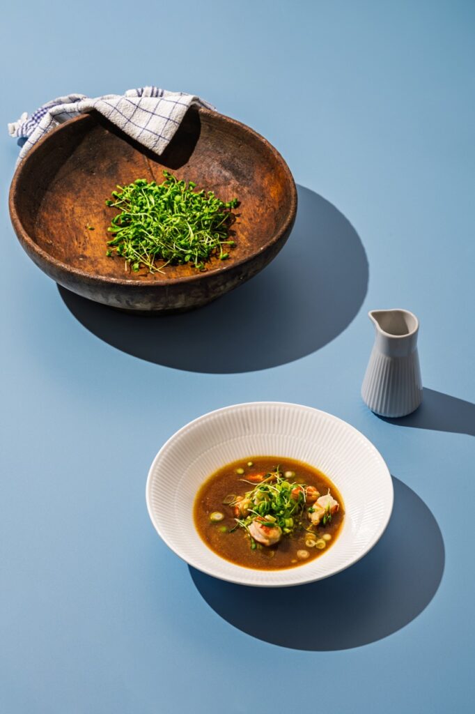 Skovgaard & Damgaard madfotografering af suppe med rejer og friske microgreens i stilren opsætning.